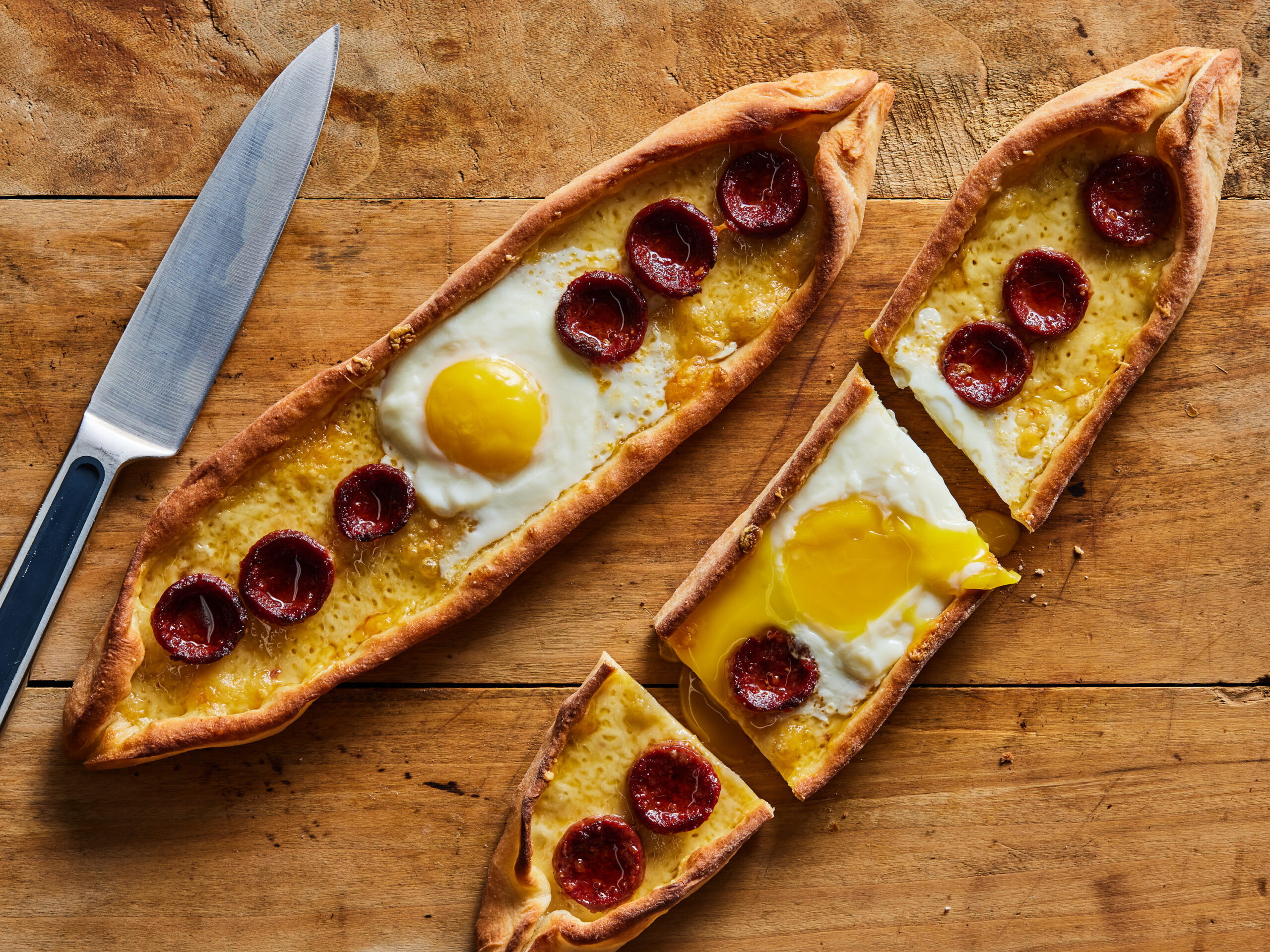 Description: Food Network Kitchen's Turkish Pide with Eggs and Sucuk. Keywords: Sugar, Flour, Instant Yeast, Kaşar, Mozzarella, Sucuk, Eggs.